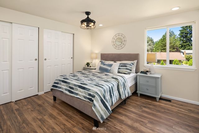 a bedroom with a bed and a large window