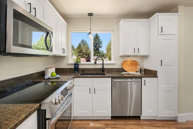 a kitchen with stainless steel appliances granite countertop a sink stove and cabinets