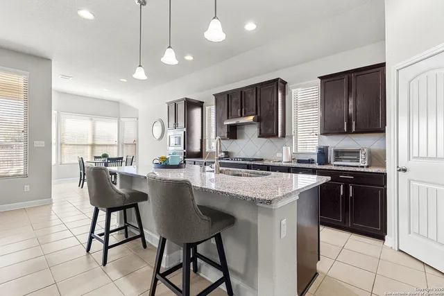 a kitchen with a counter space a sink appliances and cabinets