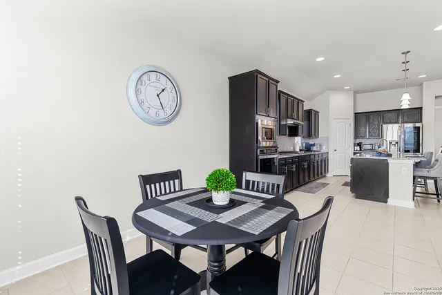 a view of a dining room with furniture a kitchen and a chandelier