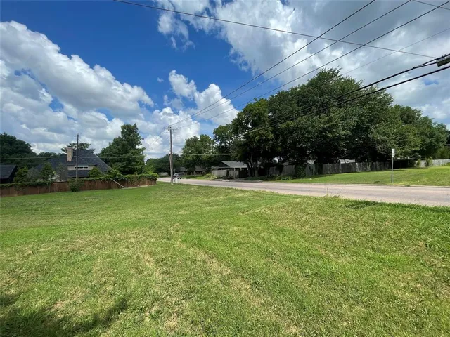 a view of a field of grass and trees