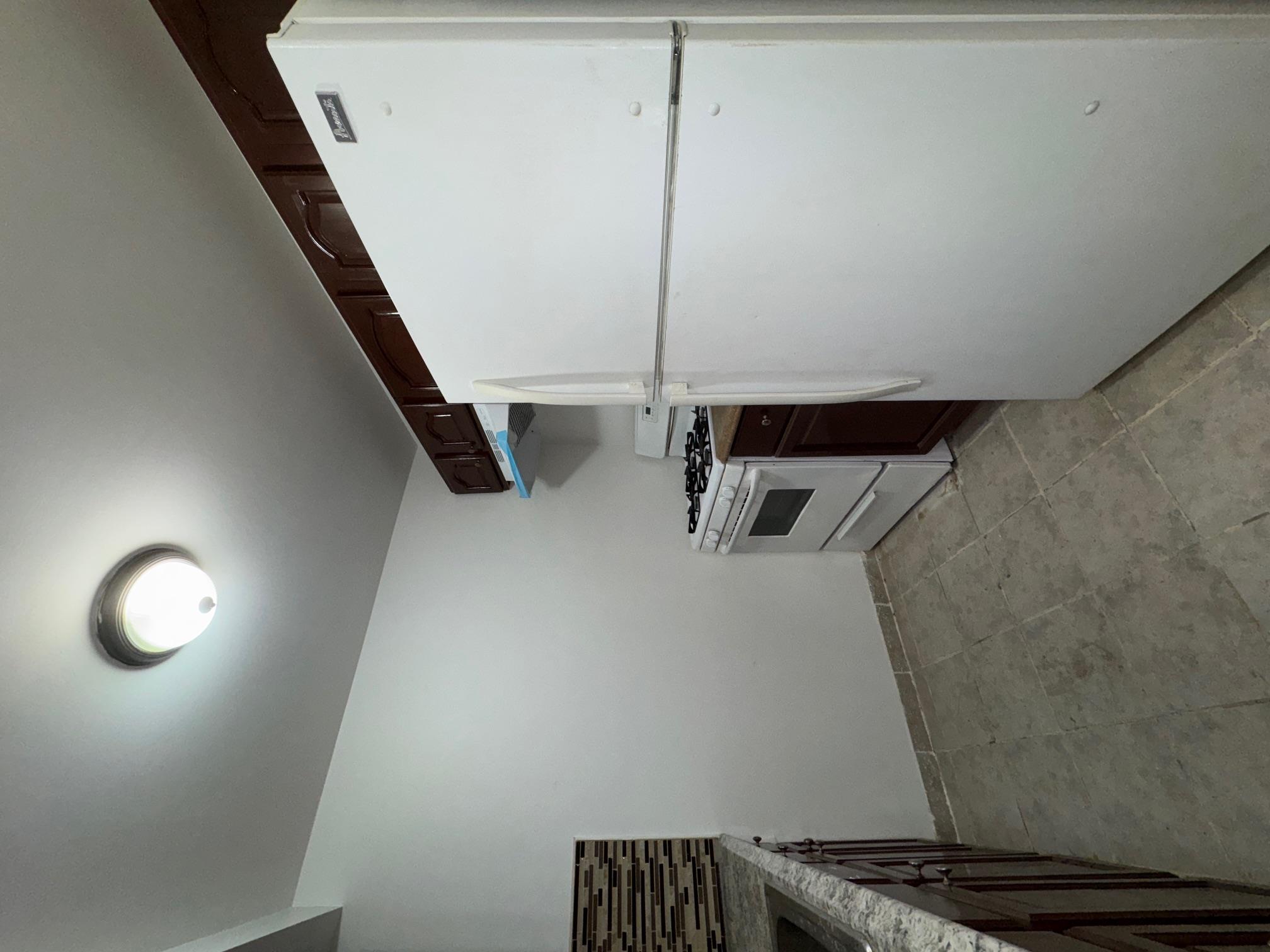 631 Coster Street Bronx, NY 10474 - Photo 11 of 19 a kitchen with a refrigerator and a stove top oven