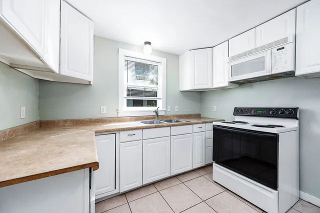 a kitchen with stainless steel appliances granite countertop a stove sink and cabinets