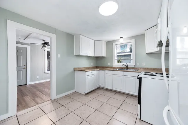a kitchen with a sink window and cabinets