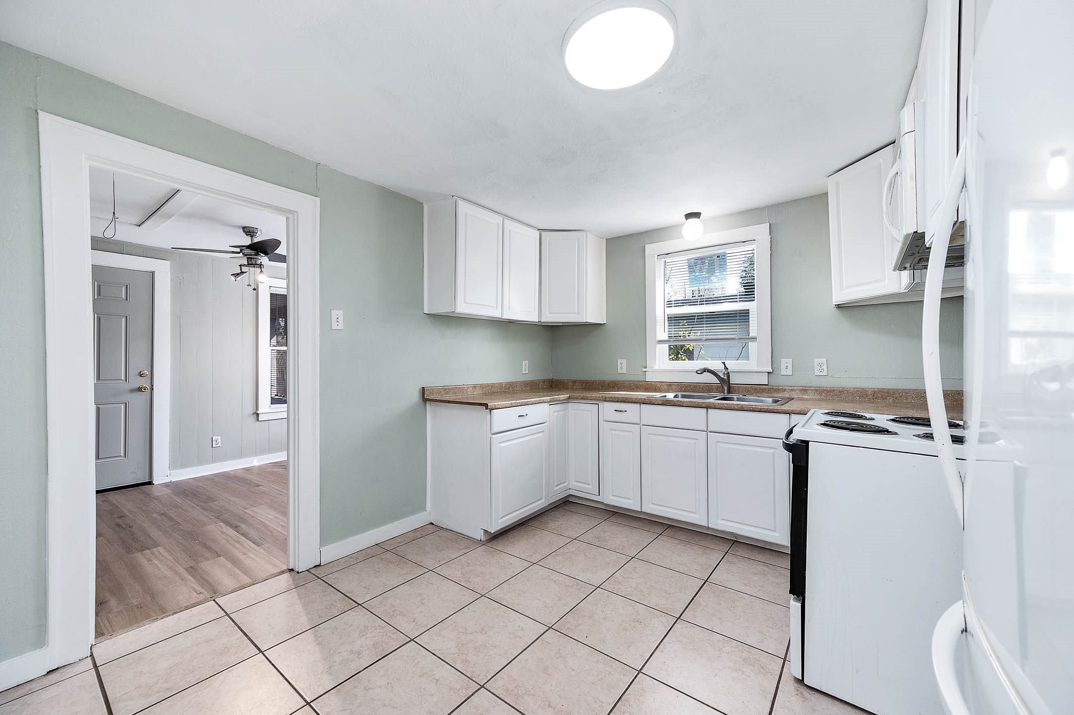 2012 Avenue F Dickinson, TX 77539 - Photo 10 of 20 a kitchen with a sink window and cabinets
