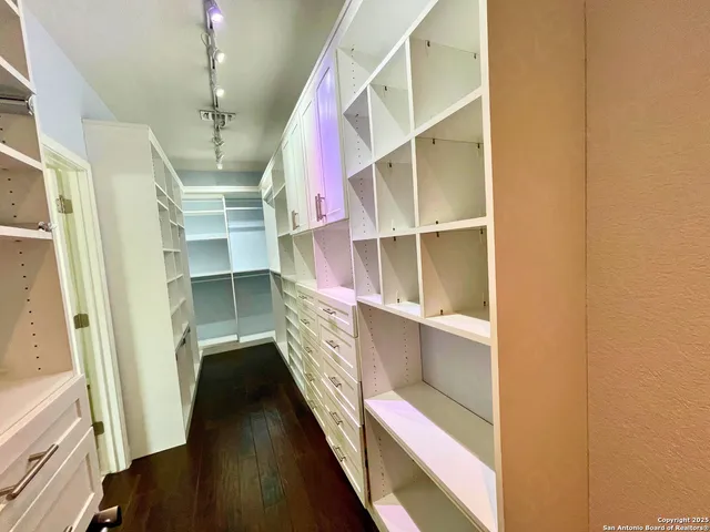 a view of walk in closet with empty racks