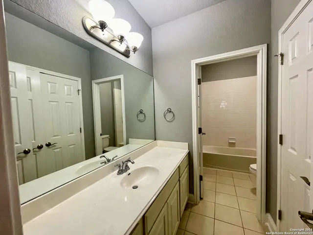 a spacious bathroom with a shower a sink and a mirror