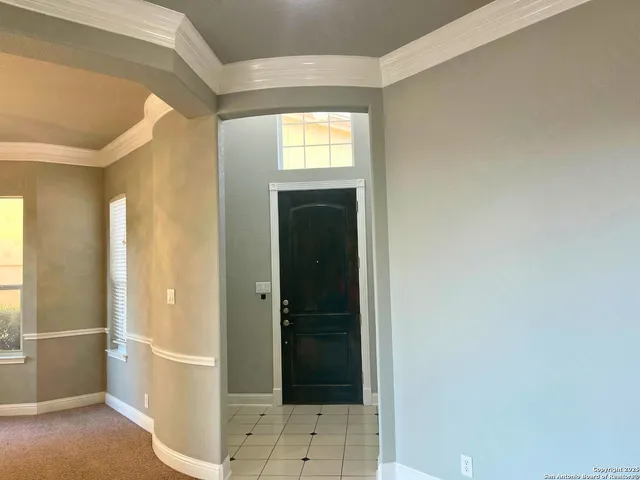 a view of a hallway with wooden floor and a bathroom