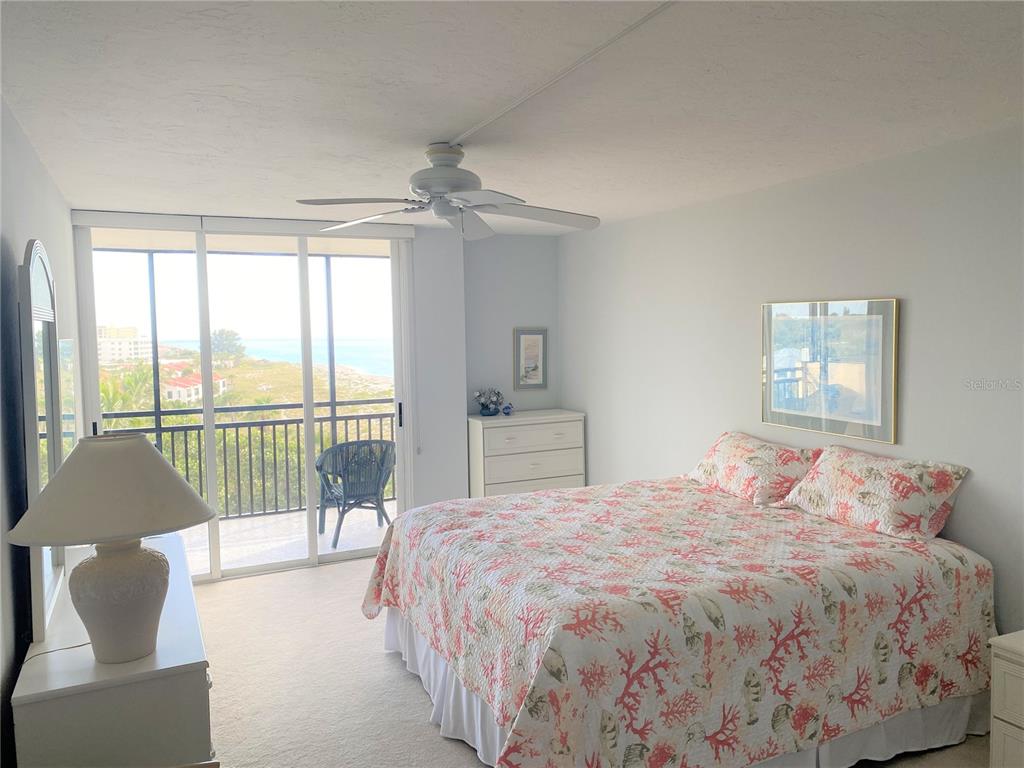 631 Alhambra Road, Unit 702 Venice, FL 34285 - Photo 12 of 14 a bedroom with a large bed and a balcony view