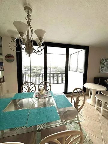 a view of a dining room with furniture water view and a floor to ceiling window