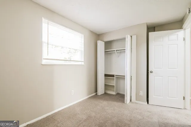 an empty room with windows and closet