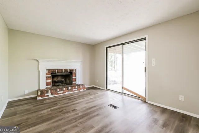an empty room with wooden floor and fireplace