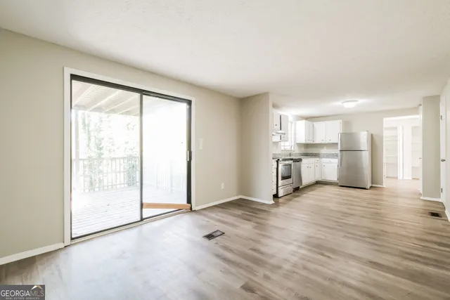 a view of a kitchen with wooden floor and electronic appliances