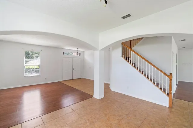 an empty room with wooden floor and window