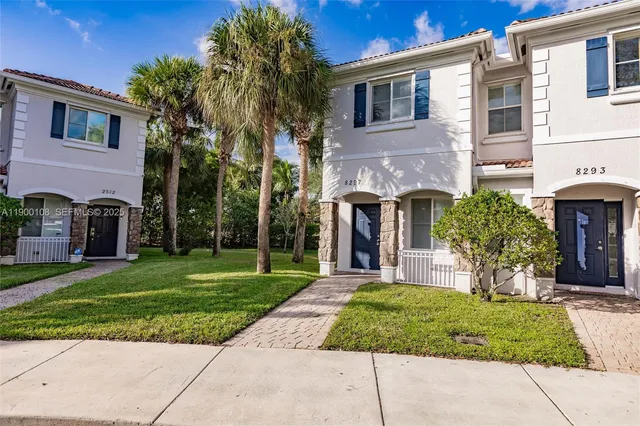 a front view of a house with a garden and plants