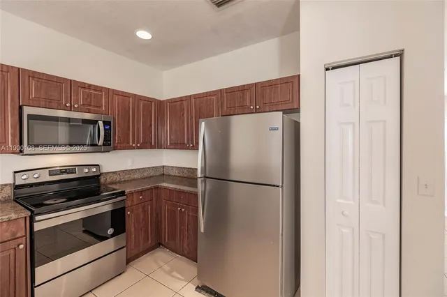 a view of kitchen with refrigerator and window