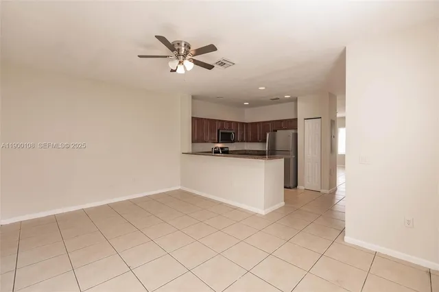 a view of kitchen with stainless steel appliances cabinets and window