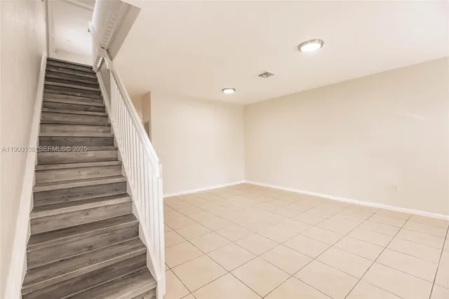 a view of a hallway with wooden floor and a window