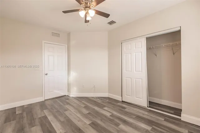 an empty room with a window and a fan
