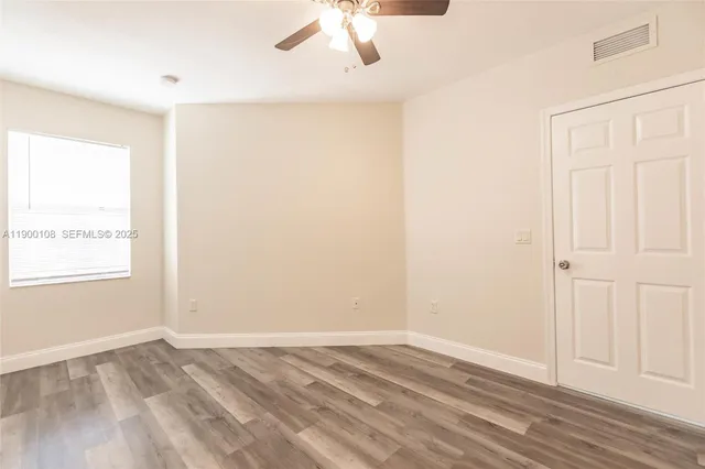a view of empty room with wooden floor