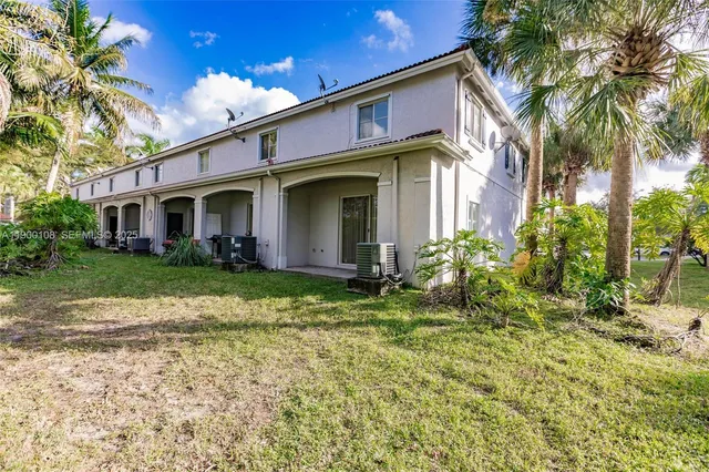 a view of a house with potted plants and a table