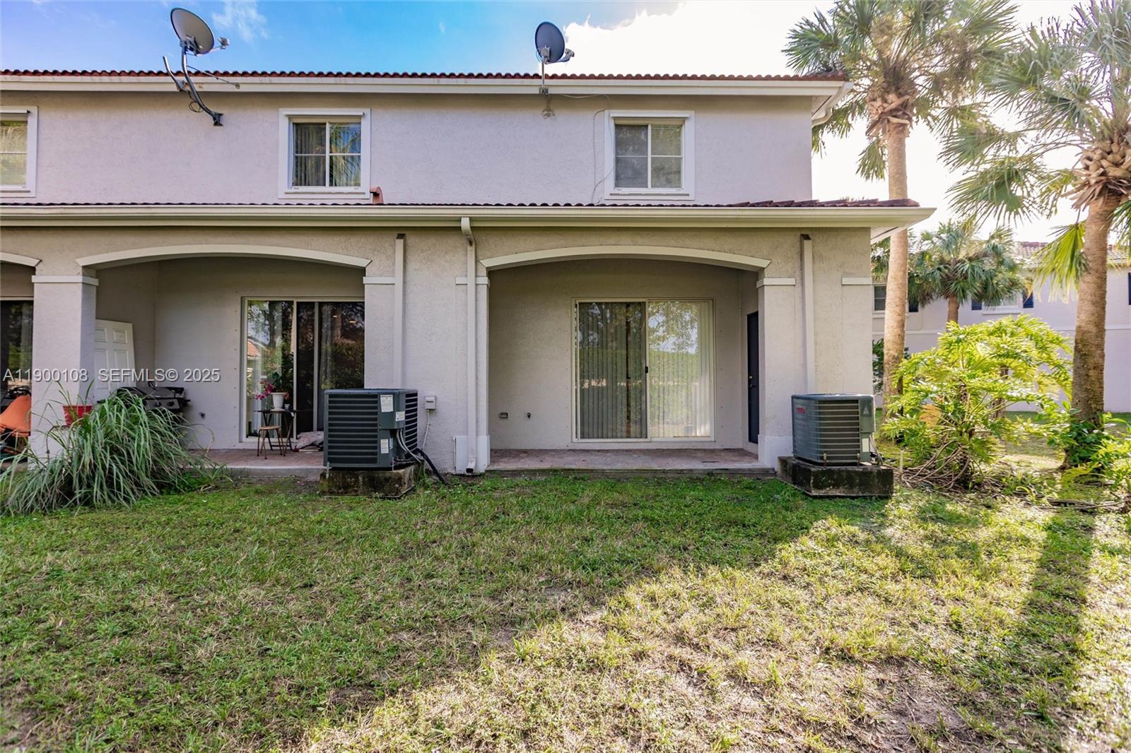 8297 Southwest 25th Court, Unit 101 Miramar, FL 33025 - Photo 33 of 42 a view of a house with potted plants and a table
