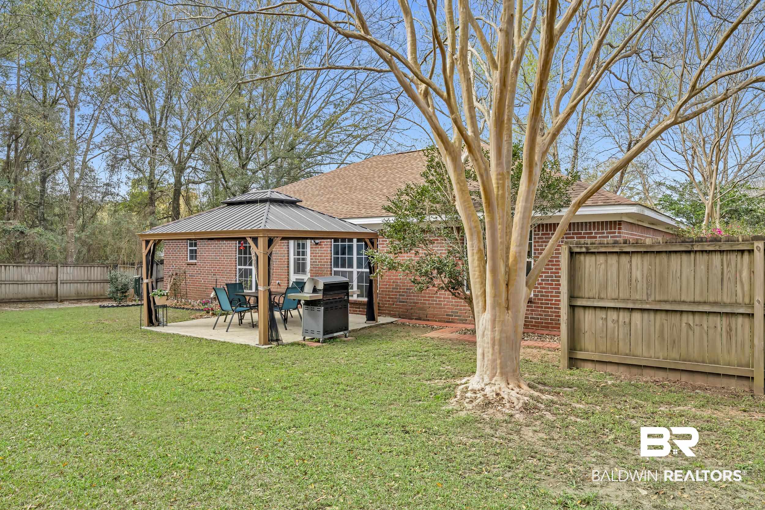 191 Robbins Boulevard Daphne, AL 36526 - Photo 21 of 24 Rear view of house featuring a fenced backyard, brick siding, a patio, and a gazebo
