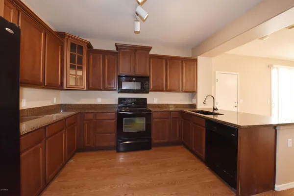 a kitchen with kitchen island granite countertop a stove sink and cabinets