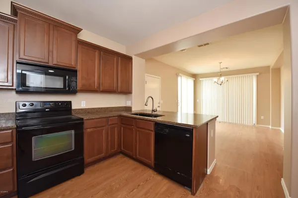 a kitchen with granite countertop wooden cabinets and a stove top oven