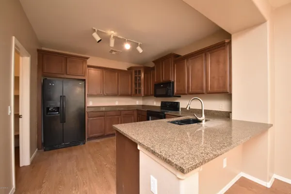 a kitchen with stainless steel appliances granite countertop a sink refrigerator and cabinets