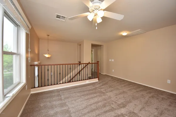 an empty room with fan and windows