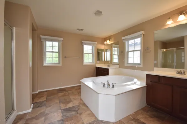 a view of spacious bathroom with a tub sink and mirror