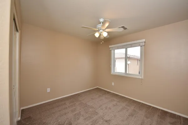 an empty room with windows and fan