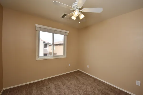 an empty room with a window and a fan