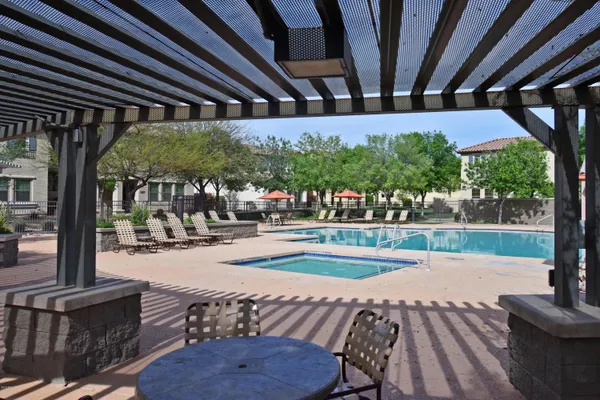 a view of a patio with table and chairs and a large tree with wooden fence