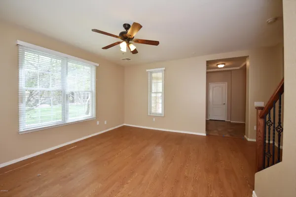 a view of an empty room with a window and wooden floor