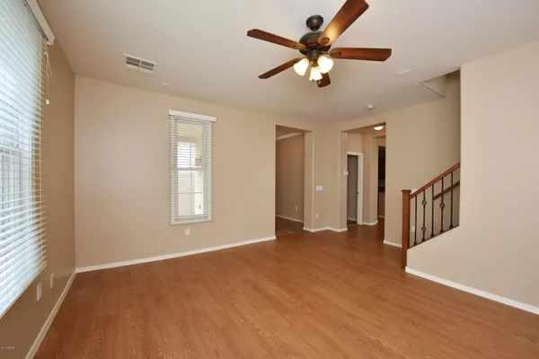 a view of an empty room with a window and a kitchen