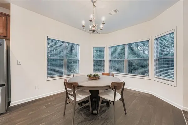 a dining room with furniture large windows and a chandelier