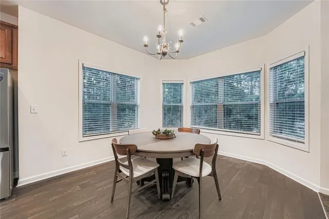 a dining room with furniture large windows and a chandelier