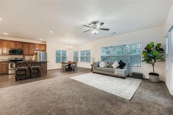 a living room with furniture a chandelier and a flat screen tv