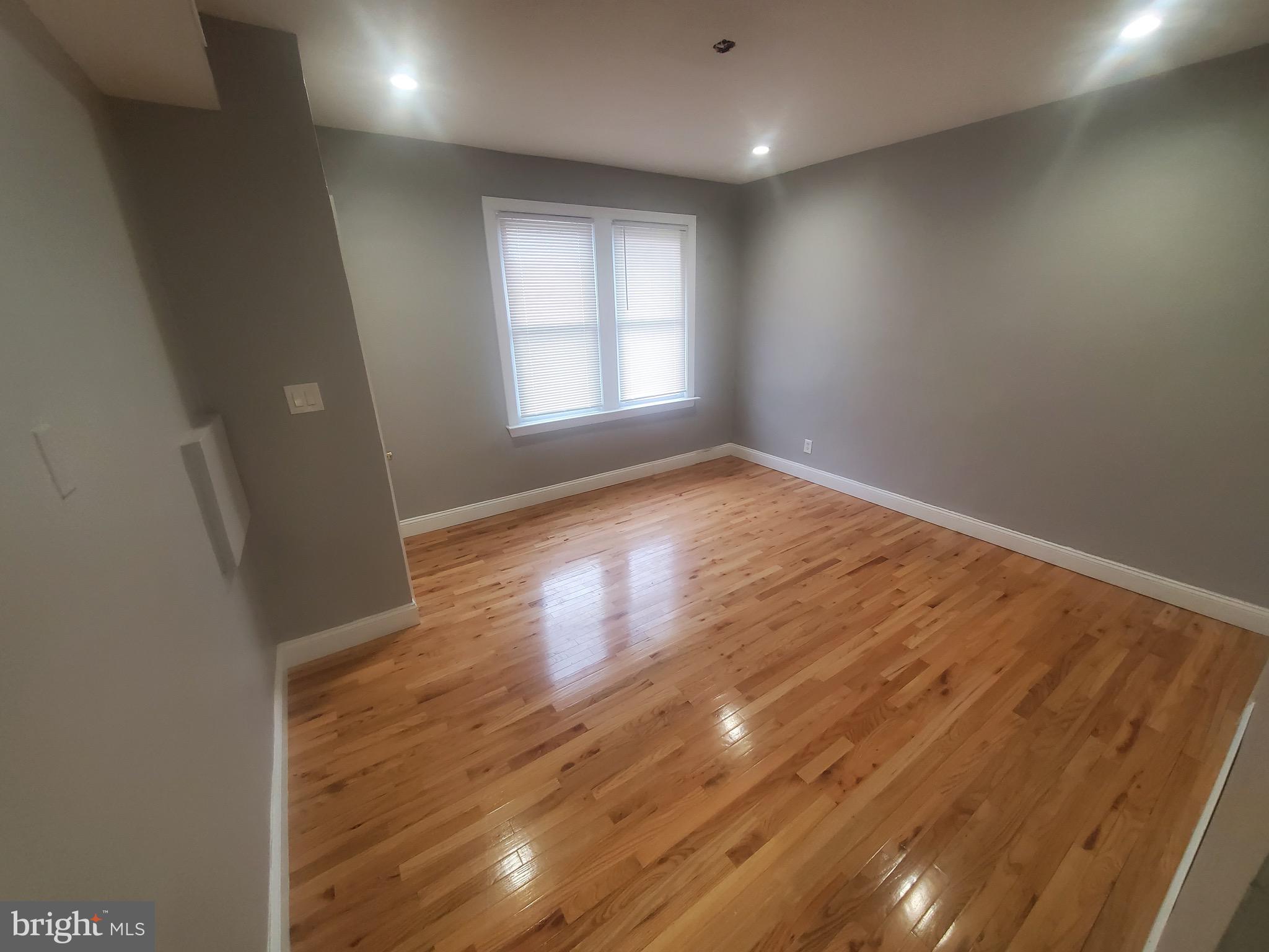 1122 Penn Street Northeast, Unit 1 Washington, DC 20002 - Photo 3 of 31 an empty room with wooden floor and windows