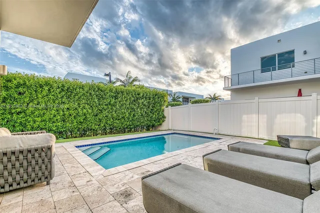 a swimming pool with outdoor seating yard and furniture