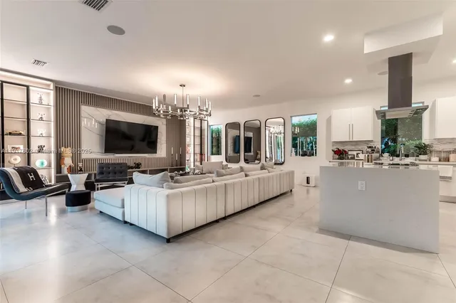 a living room with furniture chandelier and a large window