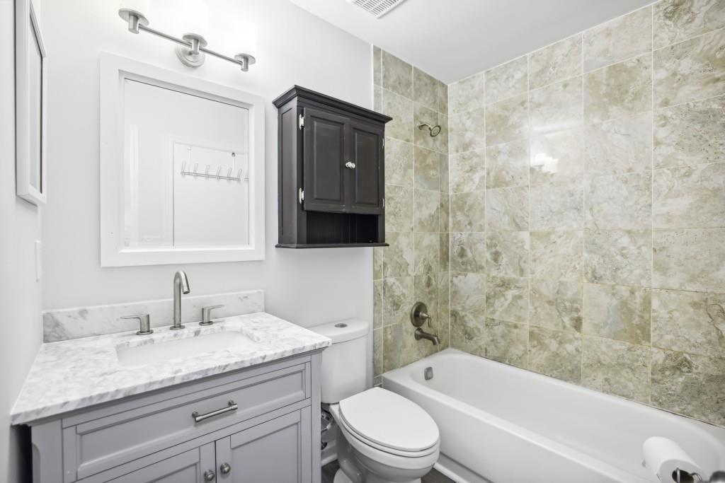 10145 Rillridge Court Alpharetta, GA 30022 - Photo 12 of 26 a bathroom with a granite countertop sink a toilet and bathtub