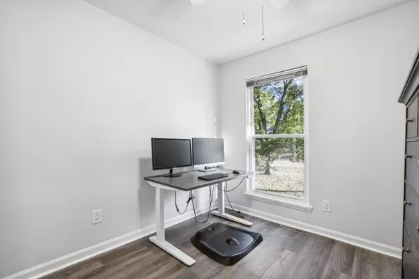 a view of a workspace with furniture and a window