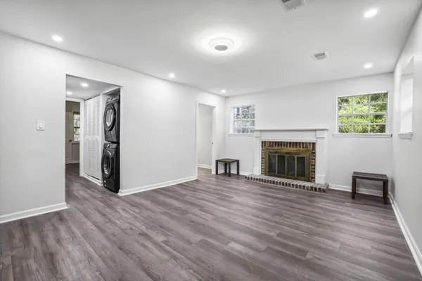 a view of a livingroom with wooden floor and a fireplace