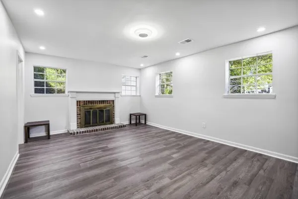 an empty room with windows and a fireplace