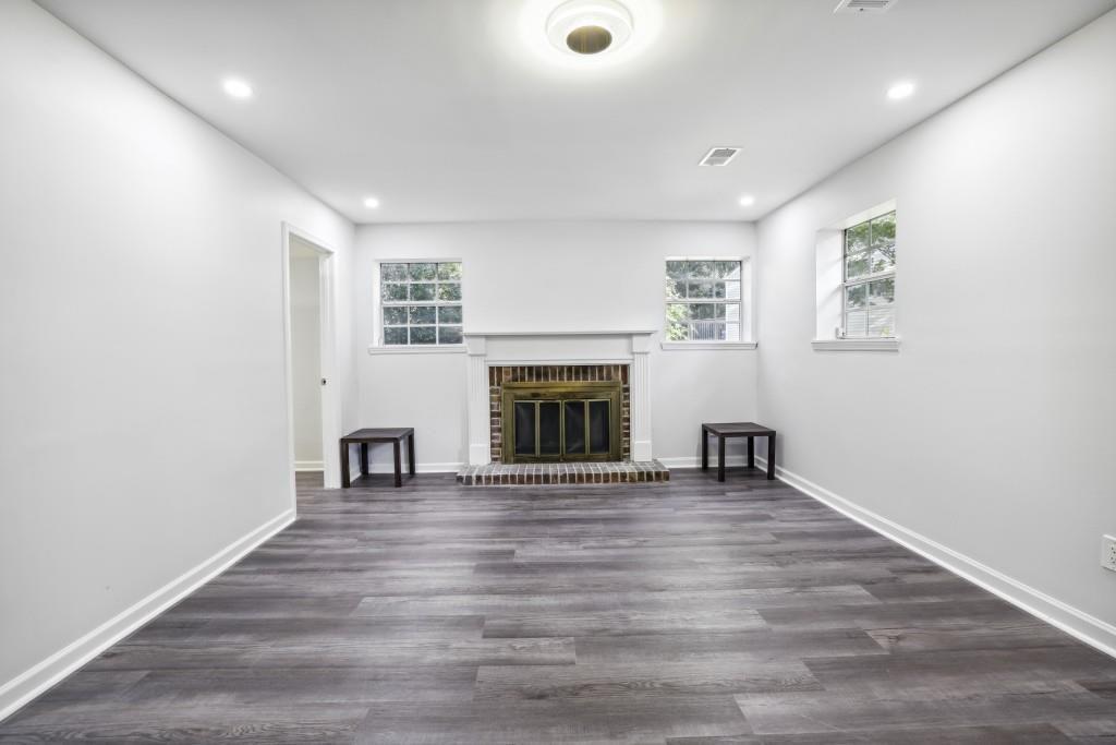 10145 Rillridge Court Alpharetta, GA 30022 - Photo 18 of 26 an empty room with wooden floor fireplace and windows