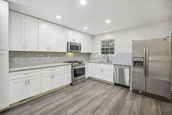 a kitchen with granite countertop white cabinets and white appliances