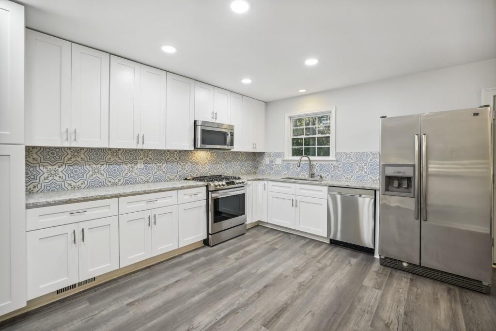 10145 Rillridge Court Alpharetta, GA 30022 - Photo 6 of 26 a kitchen with granite countertop white cabinets and white appliances